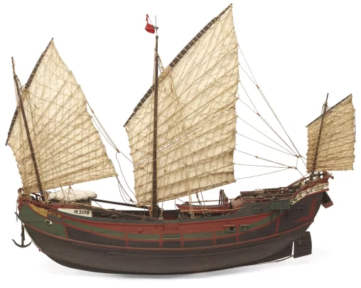A large Chinese junk ship featuring three triangular sails and mounted steering