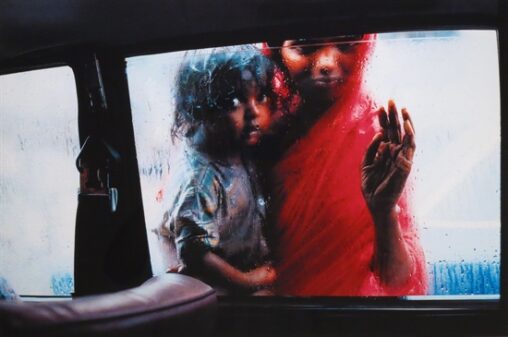 A mother and daughter from Bombay, India beg for help through a taxi window.